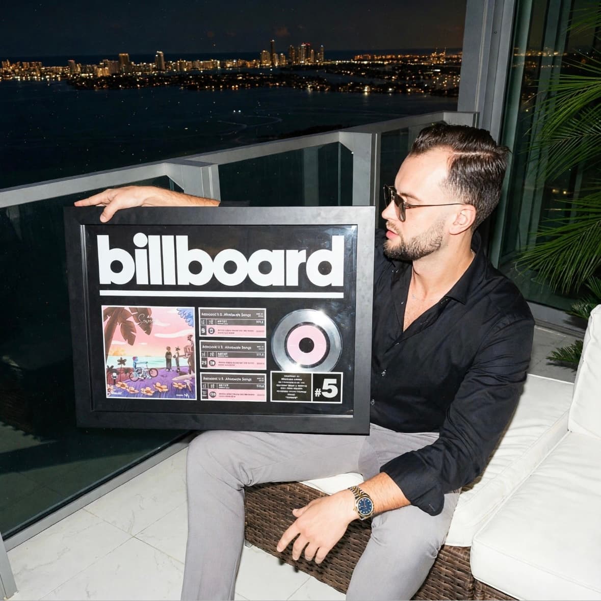 GRAUX holding a Billboard plaque for Soweto in Miami